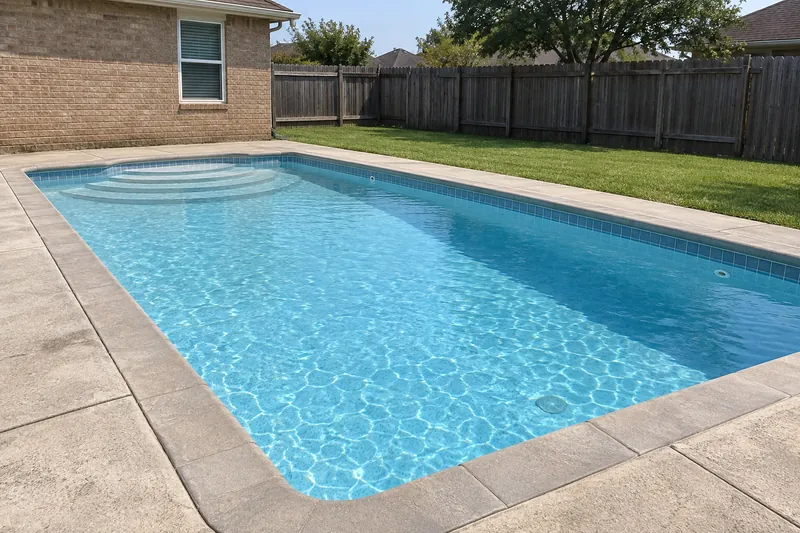 Rectangular backyard pool with a light blue quartz finish and clear water