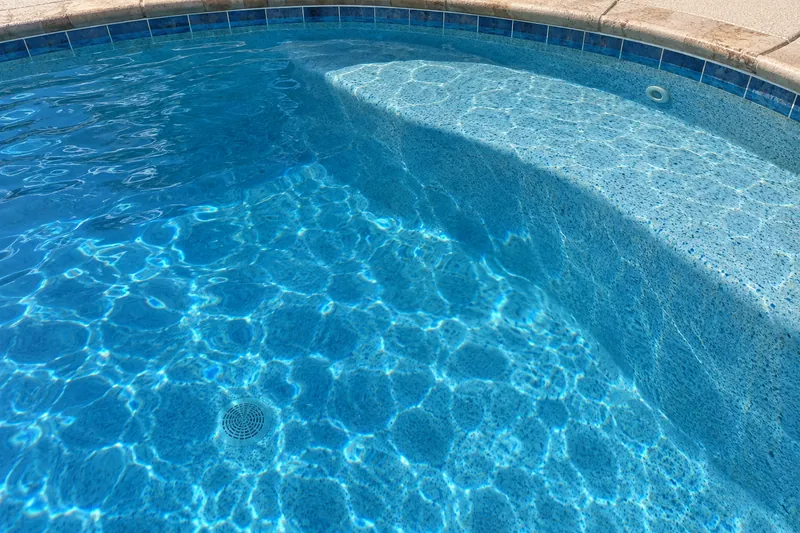 Medium blue quartz pool finish with natural shading under deep blue water