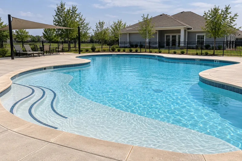 Freshly resurfaced neighborhood amenity pool beside a small clubhouse