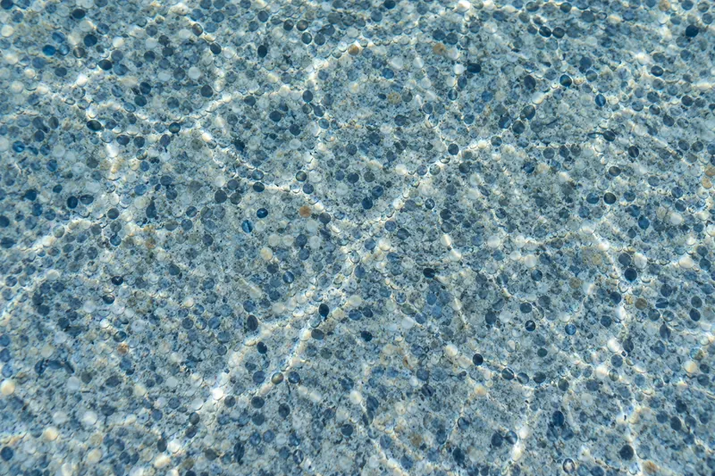 Mini pebble pool finish in a blue-gray blend under water