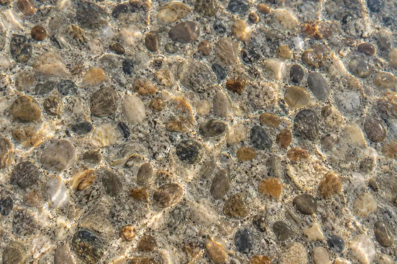 Regular-size pebble pool finish in earth tones under water